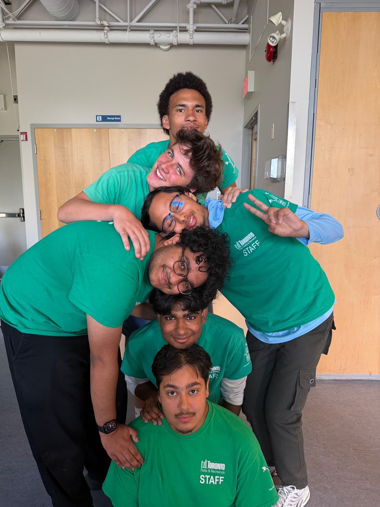 Six camp staff stacked head over head in a vertical column formation