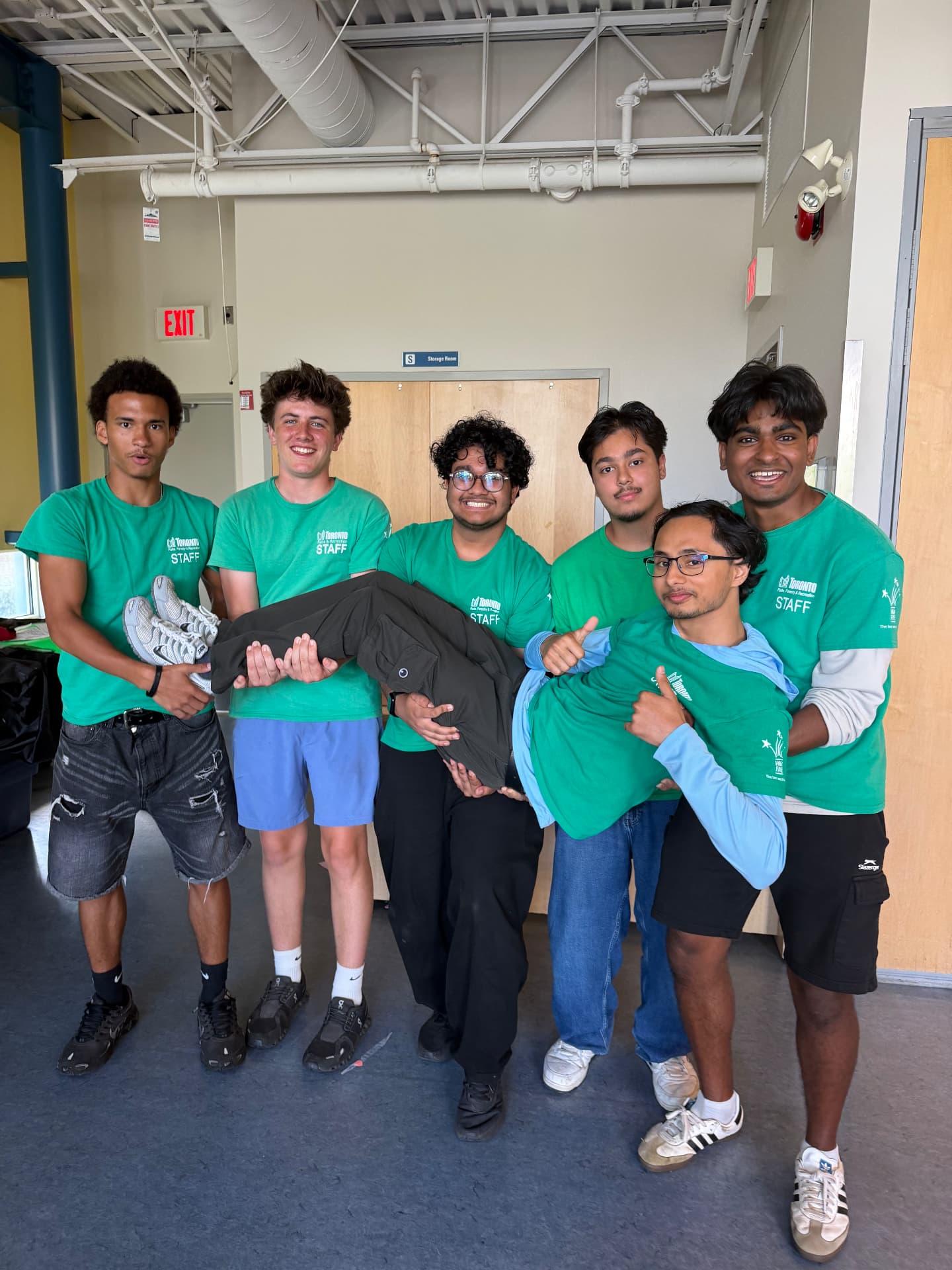 Jihan, Kayden, Faijul and Ashik carry an injured camper to the first aid station